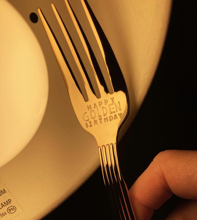 May include: A gold fork with the words "Happy Golden Birthday" engraved on the handle.
