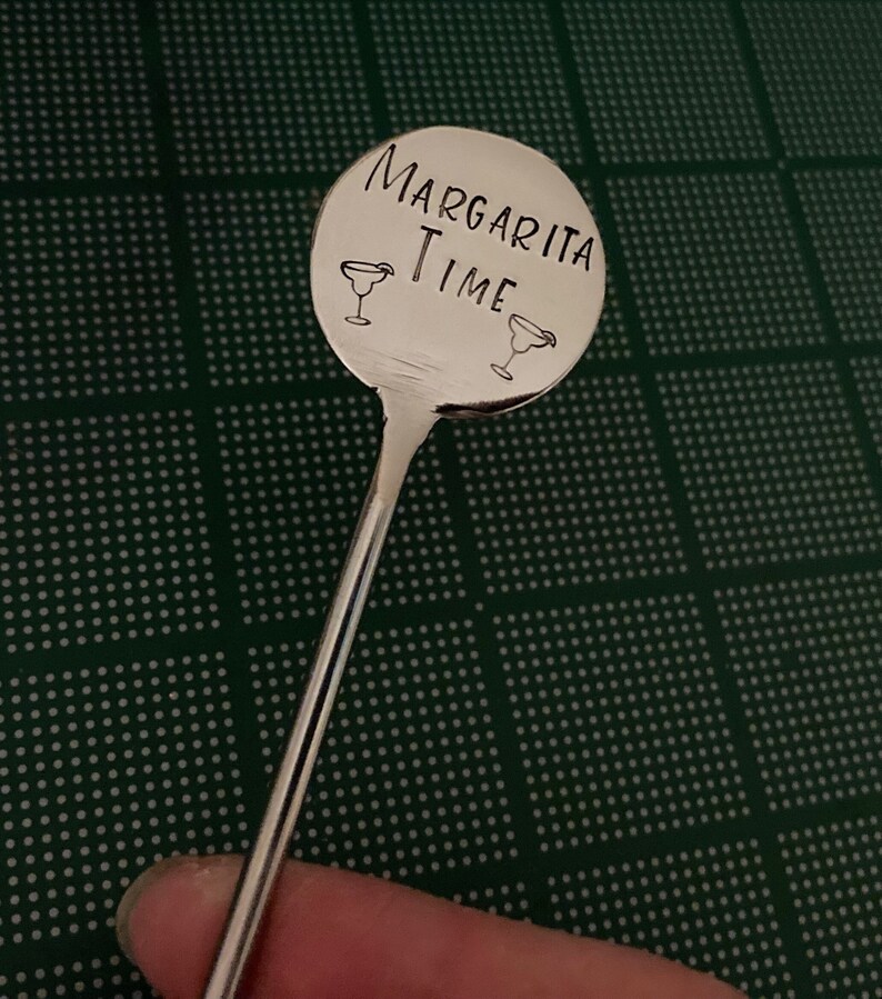 Peut inclure: Un m&eacute;langeur &agrave; margarita en argent avec une t&ecirc;te ronde grav&eacute;e qui dit "Margarita Time" avec deux ic&ocirc;nes de verre &agrave; margarita.