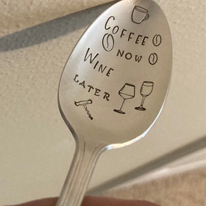 May include: A silver spoon with the text "Coffee Now Wine Later" engraved on it. The spoon also has a coffee cup, coffee bean, wine glass, and corkscrew engraved on it.