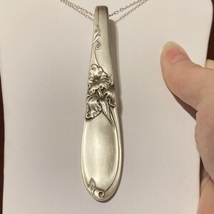 Puede incluir: Collar con colgante de plata con dise&ntilde;o en forma de cuchara. El colgante est&aacute; adornado con detalles florales y cuelga de una delicada cadena de plata. El colgante de cuchara mide aproximadamente 15 cm de largo.