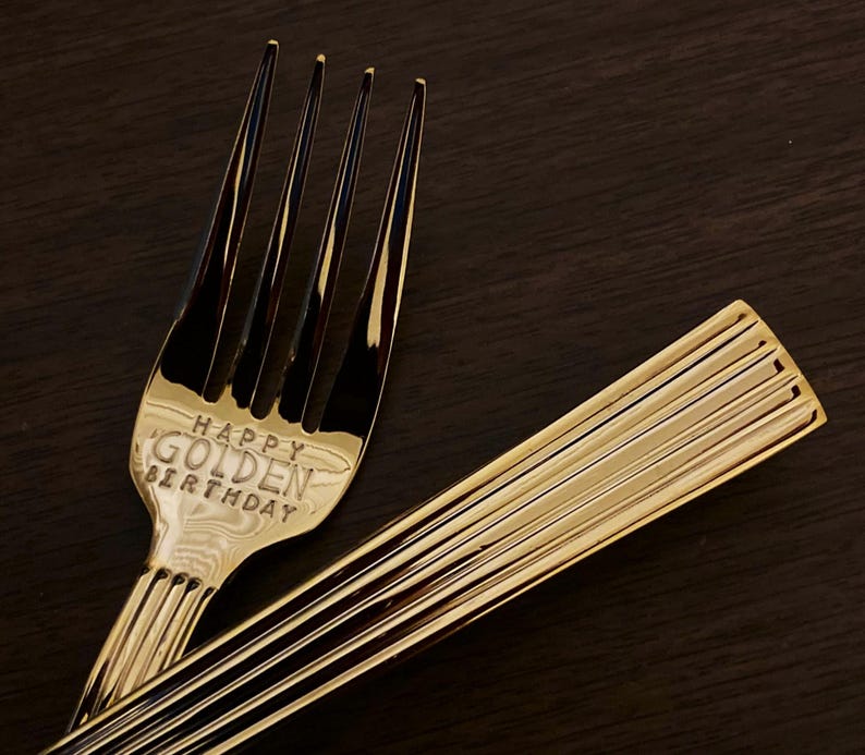 May include: Gold-colored fork with the words "Happy Golden Birthday" engraved on the handle.
