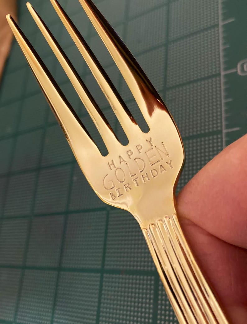 May include: A gold-colored fork with the words "Happy Golden Birthday" engraved on the handle.