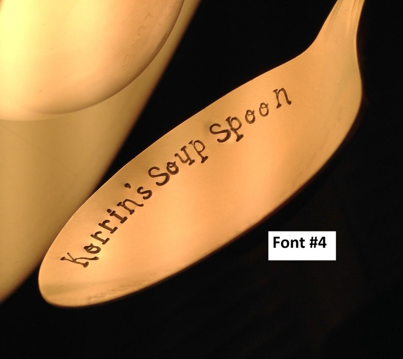 May include: Close-up of a gold-colored soup spoon with the words "Kerrins Soup Spoon" engraved on the handle. The font is a simple, elegant script.