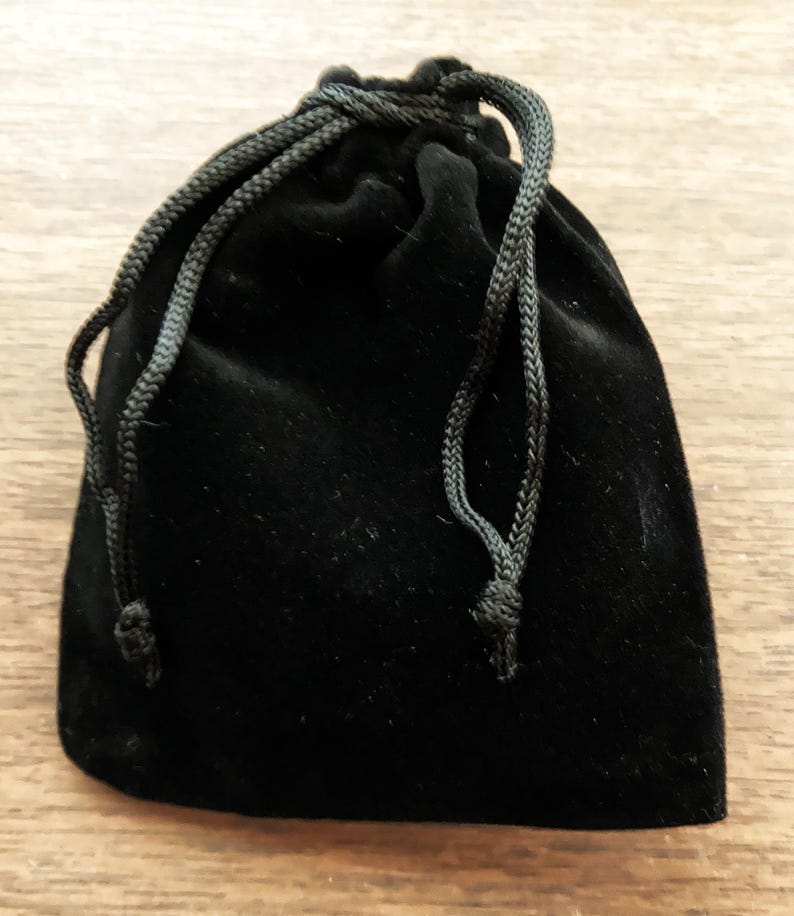 May include: A black velvet drawstring pouch with a black cord.