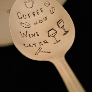 May include: A silver spoon with the text "Coffee Now Wine Later" engraved on it. The spoon also has a coffee cup, wine glass, and coffee bean illustrations.