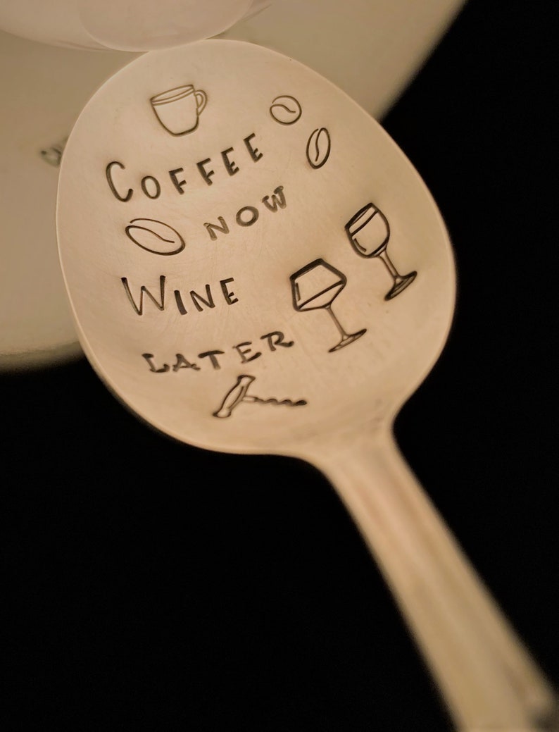 May include: A silver spoon with the text "Coffee Now Wine Later" engraved on it. The spoon also has a coffee cup, wine glass, and coffee bean illustrations.