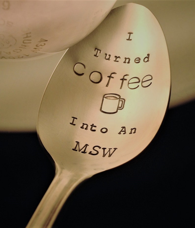 Pu&ograve; includere: Un cucchiaio in acciaio inossidabile con le parole "I Turned Coffee Into An MSW" incise nella coppetta. Un piccolo disegno di una tazza di caff&egrave; &egrave; anch'esso inciso nel cucchiaio. Il cucchiaio &egrave; angolato, con uno sfondo sfocato.