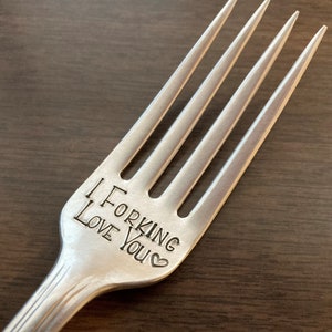 Op de afbeelding: Een zilveren vork met de woorden "I Forking Love You" gegraveerd op het handvat.