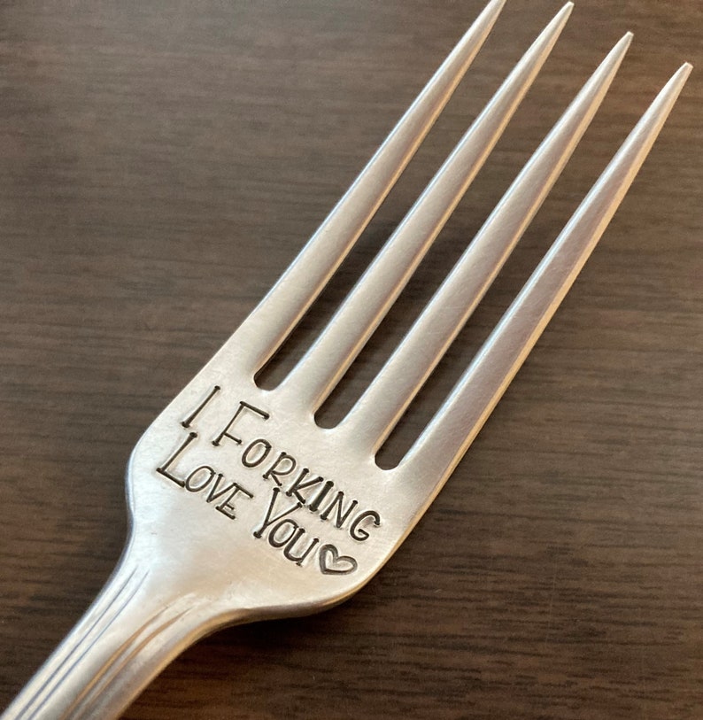 Op de afbeelding: Een zilveren vork met de woorden "I Forking Love You" gegraveerd op het handvat.