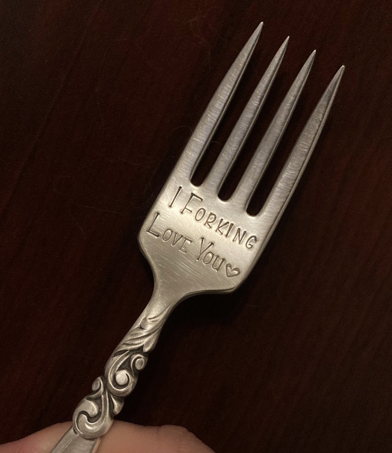 May include: A silver fork with a decorative handle engraved with the words "I Forking Love You" and a small heart.