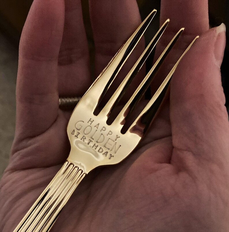 May include: A gold-colored fork with the words "Happy Golden Birthday" engraved on the handle.