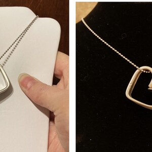 May include: A silver necklace with a heart-shaped pendant. The pendant is open and has a smooth, polished finish.