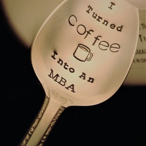 Pu&ograve; includere: Cucchiaio d'argento con la scritta incisa "I Turned Coffee Into An MBA" e un'illustrazione di tazza di caff&egrave;. Il cucchiaio ha un manico decorativo, adatto come regalo per un laureato o un amante del caff&egrave;.