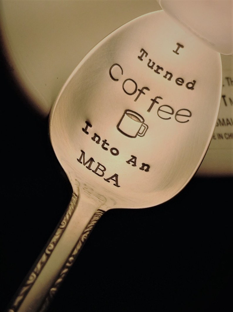 Pu&ograve; includere: Cucchiaio d'argento con la scritta incisa "I Turned Coffee Into An MBA" e un'illustrazione di tazza di caff&egrave;. Il cucchiaio ha un manico decorativo, adatto come regalo per un laureato o un amante del caff&egrave;.