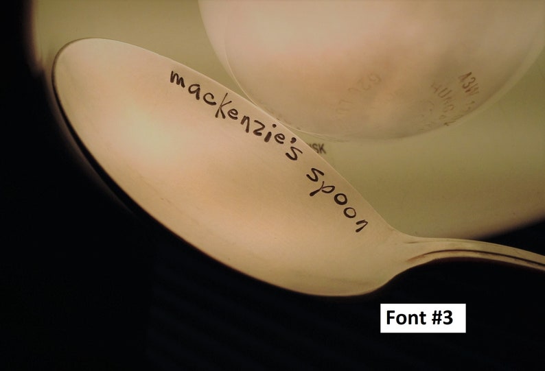 May include: A close-up of a beige spoon with the words "mackenzie's spoon" written on it in black ink.