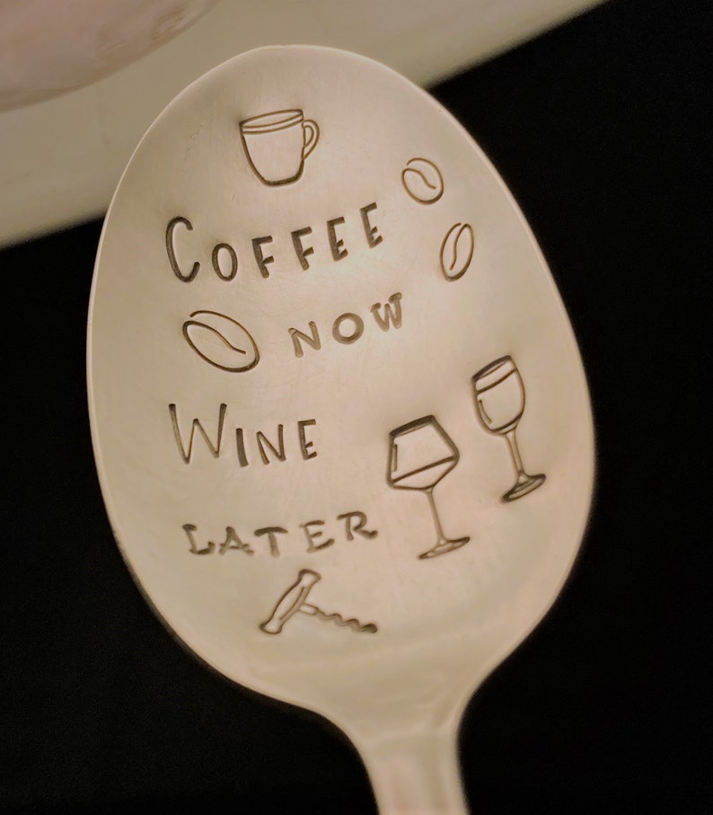 May include: A silver spoon with the text "Coffee Now Wine Later" engraved on it. The spoon also features a coffee cup, coffee beans, wine glasses, and a corkscrew.