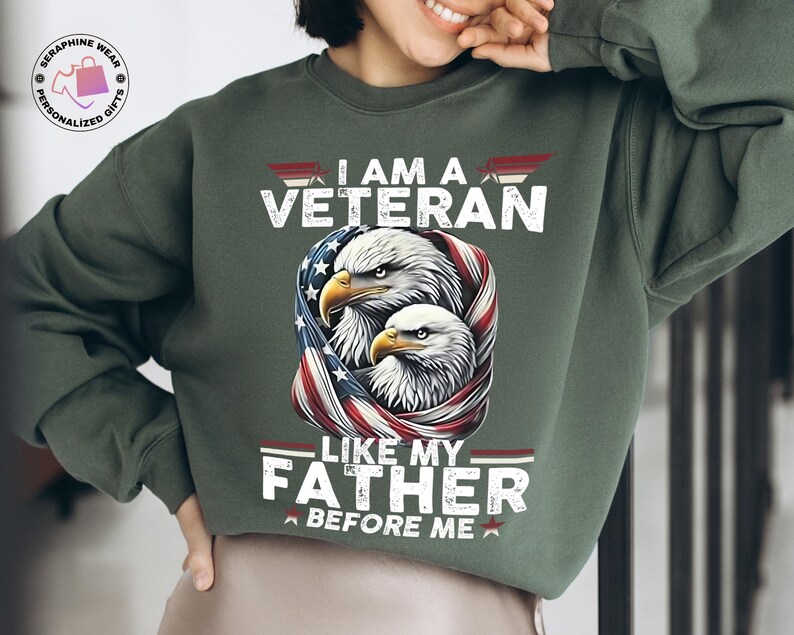 May include: Green sweatshirt featuring the text "I AM A VETERAN LIKE MY FATHER BEFORE ME" and a graphic of two eagles encircled by a US flag design. The sweatshirt is a solid green colour.