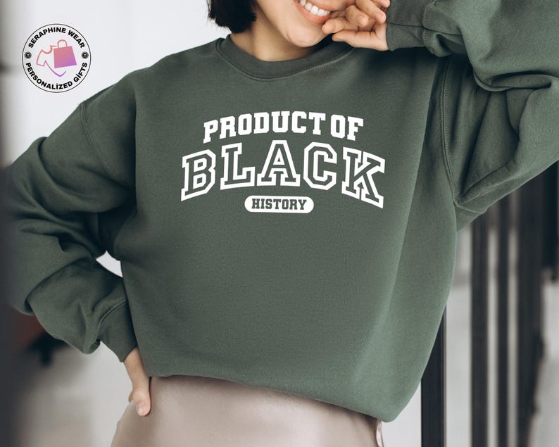 K&ouml;nnte beinhalten: Ein dunkelgr&uuml;nes Sweatshirt mit dem wei&szlig;en Text "PRODUCT OF BLACK HISTORY". Das Sweatshirt hat einen Rundhalsausschnitt und lange &Auml;rmel. Ein Logo ist in der oberen linken Ecke des Bildes zu sehen.