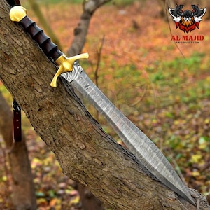 May include: A long sword with a patterned blade, gold crossguard, and a dark wooden handle, resting on a tree branch. The sword's design is intricate. The logo "AL MAJID PRODUCTION" is visible in the upper right corner.