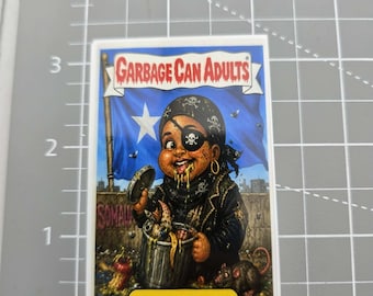 Somali Pirate Omar Garbage Can Adult, Funny Sticker, Sarcastic , Snarky Humor Sticker, ilhan Omar, Dark Humor, Garbage pail kid inspired.
