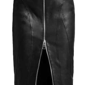 Pode incluir: Uma saia midi de couro preto com um fecho de correr metálico prateado a todo o comprimento no centro da frente, criando uma abertura. A saia inclui dois bolsos diagonais adicionais com fecho nas ancas e detalhes de costuras verticais.