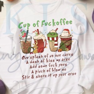 May include: White long-sleeve sweatshirt with the text "Cup of Fuckoffee" and a humorous poem. The design features four cartoon coffee cups with festive decorations. The sweatshirt is a comfortable, casual style.
