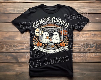 Op de afbeelding: Zwart T-shirt met een Halloween-thema. Het ontwerp bevat de tekst "Gilmore Ghouls" en toont twee cartoongeesten, een prieel en de zin "Where you haunt, I will follow."