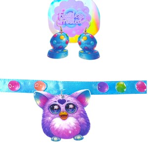 May include: A set of colorful earrings and a necklace featuring a purple Furby pendant. The earrings have blue bases and dotted spheres. The necklace has a blue band with colorful bubble accents. The background features the text "Fearless Frosted".