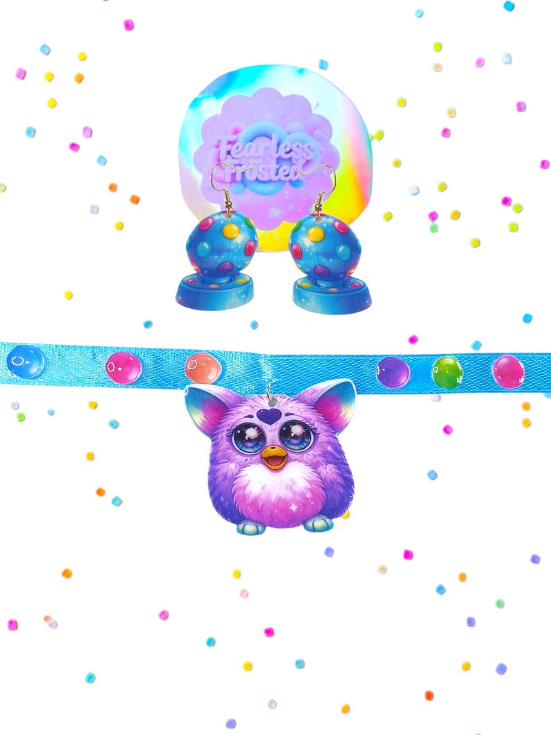 May include: A collection of colorful accessories, including a pendant and earrings. The pendant is a purple, fluffy creature with large eyes, hanging from a blue ribbon. The earrings are blue with colorful polka dots. The background features confetti.