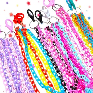 May include: A selection of brightly coloured plastic chain keyrings. The keyrings feature a variety of colours, including pink, purple, yellow, blue, and black. Each keyring has a lobster clasp and a metal ring. The chains are made of interlocking plastic links.
