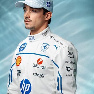 May include: A light blue and white striped baseball cap with the HP logo. The person is wearing a white racing suit with blue accents and sponsor logos, including HP, Unicredit, and AWS.