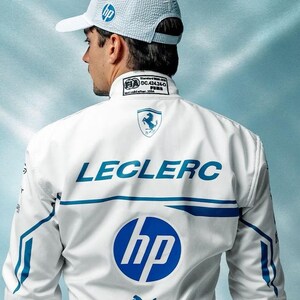 May include: A white racing jacket and cap featuring the HP logo in blue. The jacket has blue accents and the name "LECLERC" across the back. The Puma logo is visible below the HP logo.