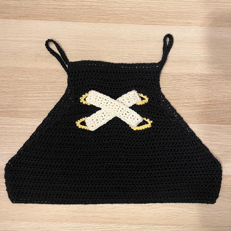 A close up shot of a crocheted black top based on Jinx from Arcane