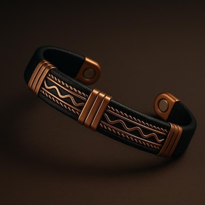 May include: Black leather cuff bracelet with copper-colored metal accents. The bracelet features a wave pattern and vertical bars. The ends of the bracelet have magnetic closures. A stylish accessory.