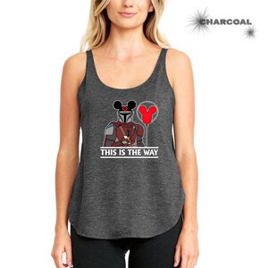 May include: A charcoal gray tank top with a graphic of a Star Wars Mandalorian character wearing Mickey Mouse ears and holding a red balloon. The text "This is the Way" is printed below the graphic.