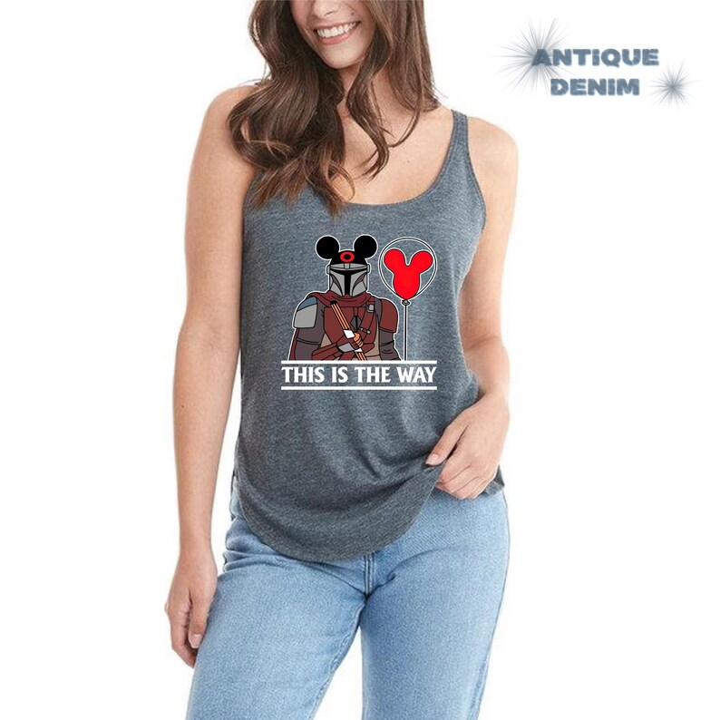 May include: A dark gray tank top with a graphic of a Star Wars character wearing Mickey Mouse ears and holding a red balloon. The text "This is the Way" is printed below the graphic.