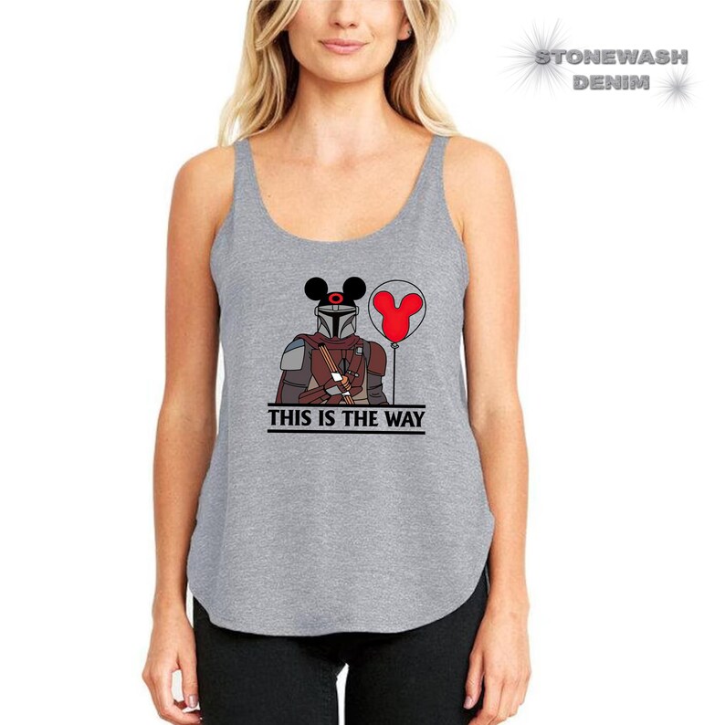 May include: Gray tank top with a graphic of a Mandalorian character wearing Mickey Mouse ears and holding a red balloon. The text "This is the way" is printed below the graphic.
