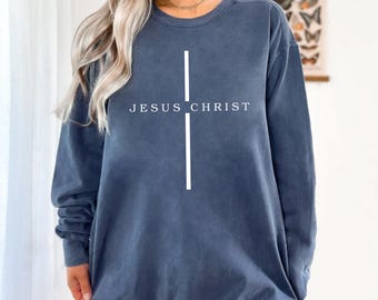 May include: A dark blue sweatshirt with a white cross and the text "JESUS CHRIST" printed on the front.