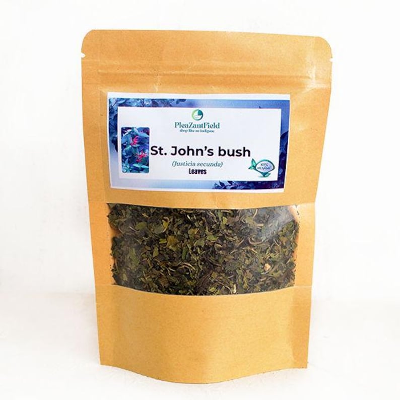 May include: A brown paper bag with a clear window displaying dried green leaves. The bag has a label that reads "St. John's bush (Justicia secunda) Leaves" with a blue and white design. The product is likely a herbal tea or medicinal herb.