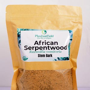Könnte beinhalten: Ein brauner Papiersack mit einem weißen Etikett mit der Aufschrift "African Serpentwood Rauwolfia vomitoria Stem Bark". Das Etikett enthält auch den Text "PleaZantField shop like an indigene" und ein grünes Blattlogo. Der Beutel enthält ein braunes Pulver.