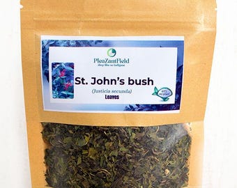 Könnte beinhalten: Ein brauner Papiersack mit einem transparenten Fenster, gefüllt mit getrockneten grünen Blättern. Ein rechteckiges Etikett zeigt den Text "St. John's bush (Justicia secunda) Leaves" und den Markennamen "PleazantField". Das Etikett hat einen blau-weißen Hintergrund.