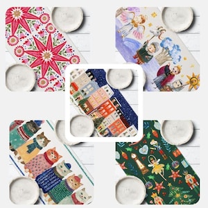 May include: A collection of five rectangular table runners featuring diverse illustrations including a red star pattern, winter scenes with angels, a city street, cats wearing sweaters, and nutcracker-themed motifs on a dark green background.