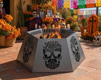 May include: A gray, hexagonal fire pit with decorative skull cutouts. The fire pit is filled with burning wood and is set outdoors, surrounded by Day of the Dead decorations, including marigolds and sugar skulls.