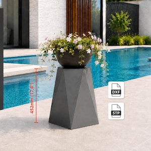 Può includere: Un piedistallo geometrico grigio scuro alto 452 mm, con una ciotola scura riempita di fiori bianchi e rosa. Il piedistallo presenta pannelli laterali piatti e angolati ed è contrassegnato da icone di formato file DXF e STP.