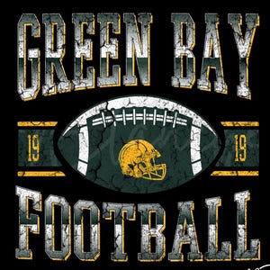 May include: A black graphic design featuring the words "GREEN BAY FOOTBALL" in distressed white and yellow lettering. A football with a yellow helmet graphic is in the center. The number "19" is on either side of the football.