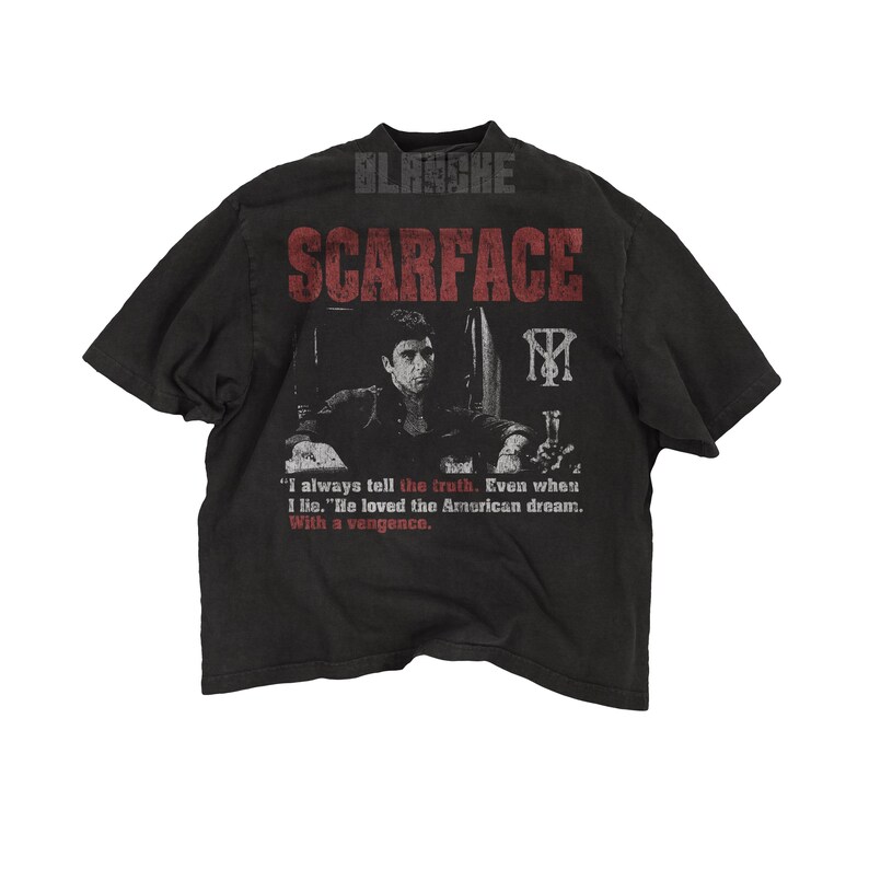 K&ouml;nnte beinhalten: Dunkelgraues T-Shirt mit dem Wort "SCARFACE" in Rot &uuml;ber einem Schwarz-Wei&szlig;-Bild eines Mannes. Das T-Shirt enth&auml;lt auch ein Zitat und den Markennamen "BLANCHE".