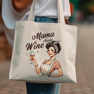 May include: Cream-colored tote bag featuring a vintage illustration of a woman holding a wine glass. The text "Mama Needs Wine" is displayed above the woman. The woman is wearing a polka-dot dress and apron.