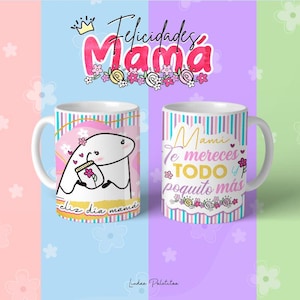 May include: Two white ceramic mugs with pink and blue stripes. One mug features a cartoon illustration of a creature holding a jar with a flower. The text on the mug reads "Feliz dia mama". The other mug features the text "Mami te mereces TODO y poquito m&aacute;s".