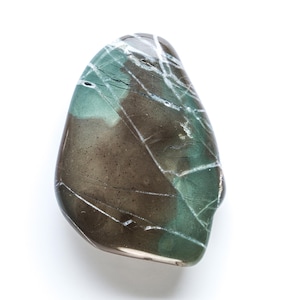 May include: A polished, teardrop-shaped stone with a mix of earthy brown and teal green hues. White veins crisscross the surface, creating a unique pattern. The stone has a smooth, glossy finish.