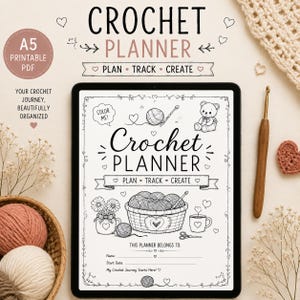 Può includere: Un tablet digitale che mostra una copertina per un planner all'uncinetto stampabile in formato A5 con illustrazioni a linee bianche e nere di filati, un orsacchiotto e fiori. Il testo recita Crochet Planner, Plan, Track, Create.